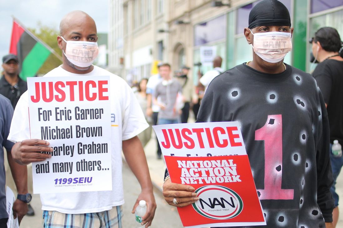 Two men wear hospital masks evoking Garner’s repeated complaint to the NYPD while in the fatal chokehold.